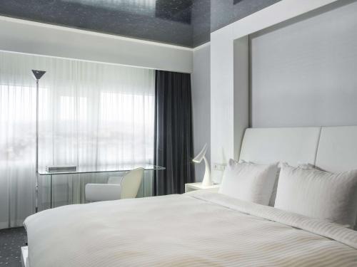 a bedroom with a large white bed and a window at Radisson Blu Plaza Hotel, Oslo in Oslo