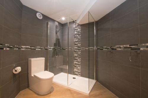 a bathroom with a toilet and a glass shower at Melfort Pier & Harbour Resort in Kilmelfort