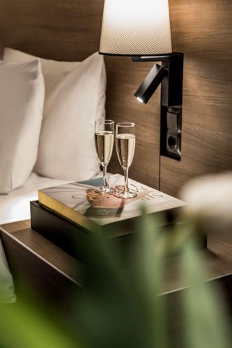 two glasses of champagne on a table next to a bed at Radisson Blu Plaza Hotel, Oslo in Oslo