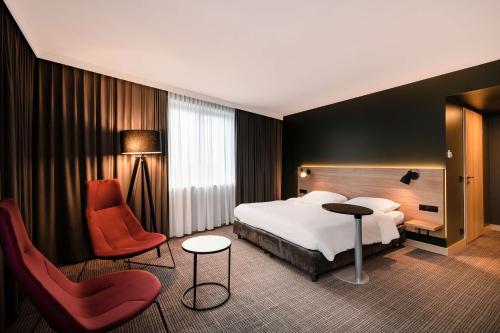 a hotel room with a bed and a chair at Park Inn by Radisson Krakow in Kraków