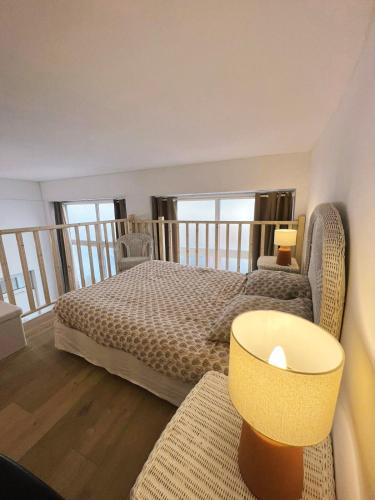1 dormitorio con 1 cama y balcón con ventanas en Appartement studio loft cosy centre st Etienne, en Saint-Étienne