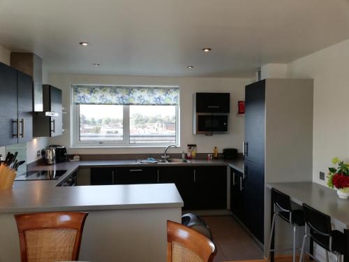 a kitchen with black cabinets and a window and a counter at Apartment in Newbury Parkway Centre in Newbury