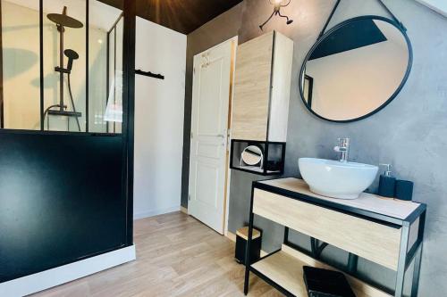 ein Bad mit einem Waschbecken und einem Spiegel in der Unterkunft Ti-vakañsoù - maison de vacances in Roscanvel