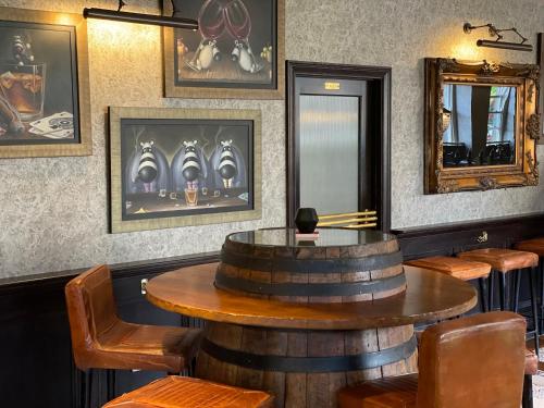 a bar with a wooden barrel table and chairs at The Queens Head, Parkside apartment 3 in Burley in Wharfedale