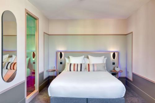 a bedroom with a large white bed and a window at Aiden by Best Western Clermont-Ferrand Hotel & Spa in Clermont-Ferrand