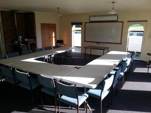 a conference room with tables and chairs and a whiteboard at Motel Sierra in Whangarei