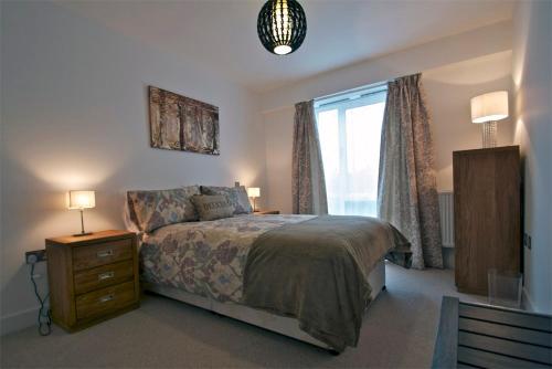 1 dormitorio con 1 cama con tocador y ventana en Apartment in Newbury Parkway Centre, en Thatcham