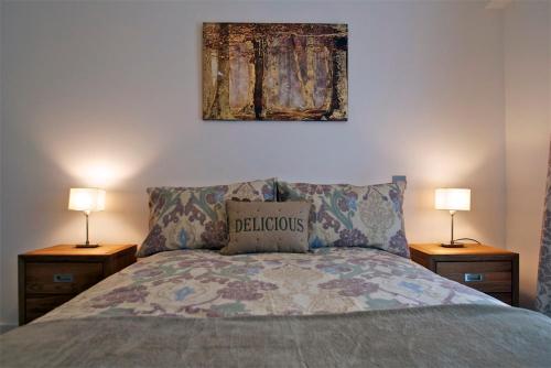 um quarto com uma cama com dois candeeiros e uma imagem na parede em Apartment in Newbury Parkway Centre em Thatcham