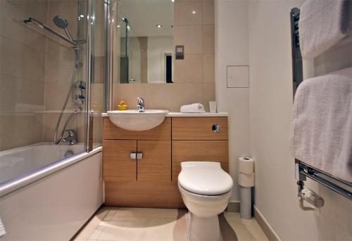 a bathroom with a toilet and a sink and a shower at Apartment in Newbury Parkway Centre in Thatcham