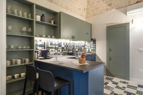 een keuken met blauwe kasten en een aanrecht met stoelen bij Civico40 Suite in Locorotondo