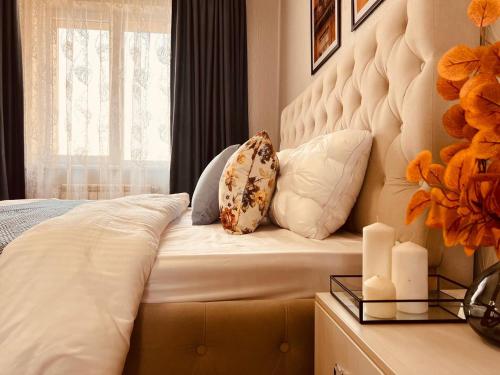 阿拉木圖的住宿－Уютная квартира в центре Алматы с потрясающими видами，卧室配有带枕头的床铺和窗户。