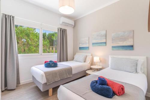 two beds in a room with a window at Casa a metros del Mar in Playa de Muro