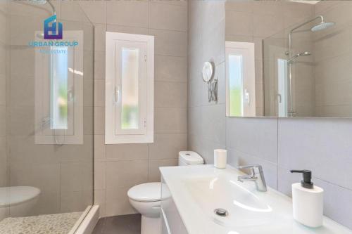 bagno con lavandino, servizi igienici e specchio di Casa a metros del Mar a Playa de Muro