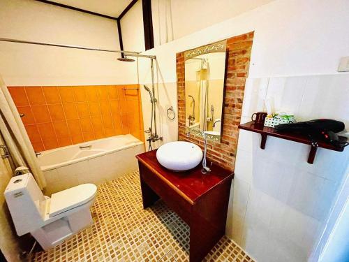 uma casa de banho com um WC, um lavatório e uma banheira em Vieng Savanh II Hotel em Luang Prabang