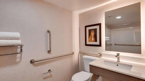 ein Badezimmer mit einem WC, einem Waschbecken und einem Spiegel in der Unterkunft Aiden by Best Western Scottsdale North in Scottsdale