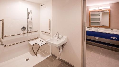 La salle de bains est pourvue d'un lavabo et d'une douche. dans l'établissement Aiden by Best Western Cape Cod - West Yarmouth, à West Yarmouth