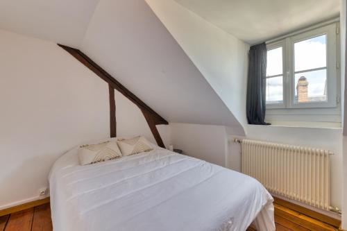 ein weißes Bett in einem Zimmer mit Fenster in der Unterkunft Michael : beau *F3* La Bouille in La Bouille
