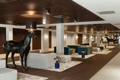 a horse statue in a lobby with couches and chairs at Radisson Blu Resort & Conference Center, Ostróda Mazury in Ostróda