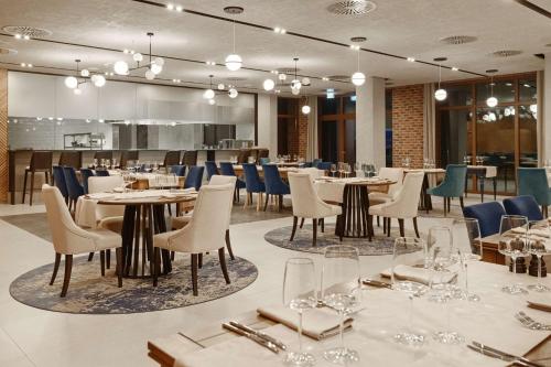 a restaurant with tables and chairs in a room at Radisson Blu Resort & Conference Center, Ostróda Mazury in Ostróda