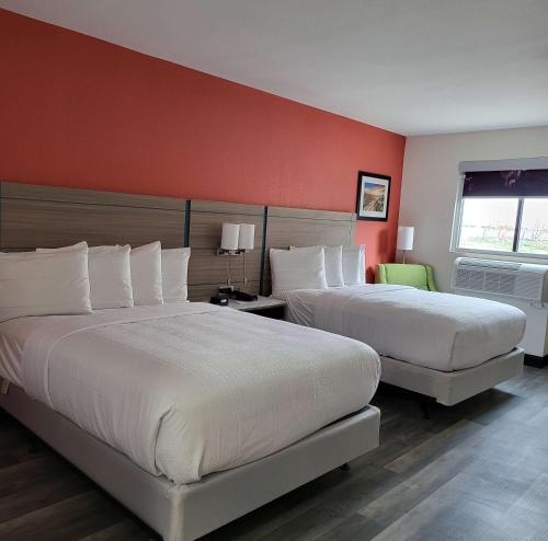 2 letti in una camera d'albergo con pareti rosse di Best Western Plus Executive Residency Carlsbad Hotel a Carlsbad