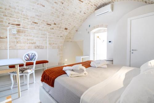 een witte slaapkamer met een bed en een bureau bij Civico40 Suite in Locorotondo