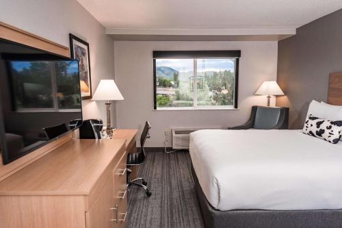 a hotel room with a bed and a desk with a television at Aiden by Best Western Denver West Golden in Golden