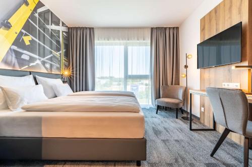 施泰爾的住宿－Aiden by Best Western Stadtgut Hotel Steyr - FREE PARKING，配有一张床和一张书桌的酒店客房