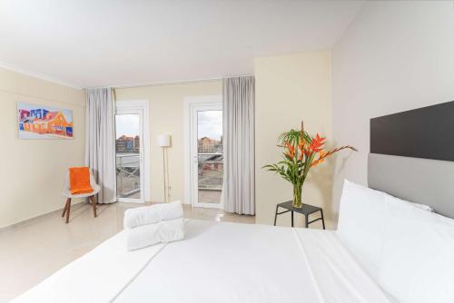 una camera bianca con un grande letto e una finestra di Brion City Hotel BW Signature Collection a Willemstad