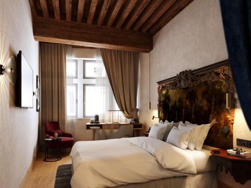 a bedroom with a large bed and a large window at Cour des Loges Lyon, A Radisson Collection Hotel in Lyon