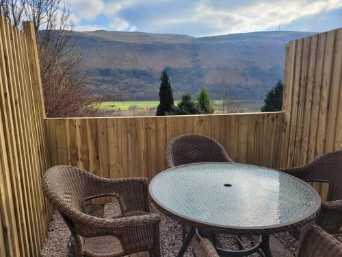 a table and chairs on a patio with a view at Mountain View Cottage sleep 6 sofabed quaint and quirky cottage in Ystalyfera