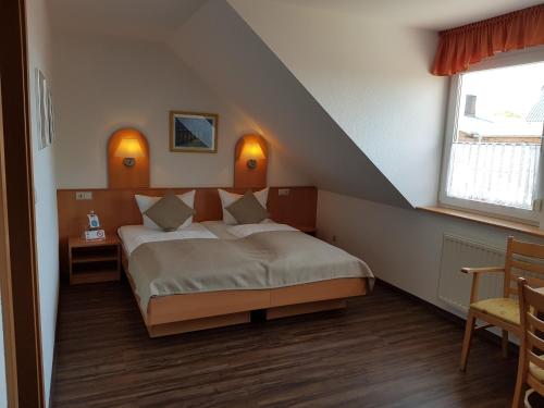 um quarto com uma cama num quarto com uma janela em Land-gut-Hotel Seeblick em Klietz