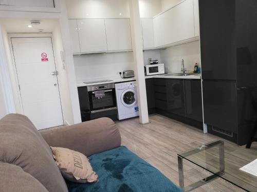 a living room with a couch and a kitchen at Convenient 1 Bed Apartment in the centre of Newbury in Newbury