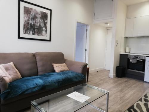 a living room with a couch and a glass table at Convenient 1 Bed Apartment in the centre of Newbury in Newbury