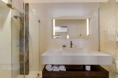 a bathroom with a white sink and a mirror at SureStay Plus Hotel by Best Western Tempe University in Tempe