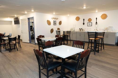 a dining room with tables and chairs and a kitchen at Bhagat Hotels Stone Mountain Atlanta BW Signature Collection in Tucker