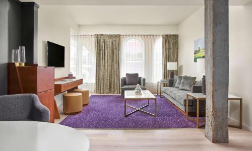 a living room with a couch and a table at The Bankers Alley Hotel Nashville, Tapestry Collection by Hilton in Nashville