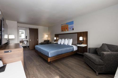 a hotel room with a bed and a couch at Bhagat Hotels Stone Mountain Atlanta BW Signature Collection in Tucker