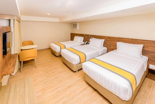 a hotel room with two beds and a television at SureStay Plus by Best Western Cebu City in Cebu City
