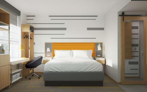 a bedroom with a bed and a desk and a chair at Hampton Inn by Hilton New York Times Square in New York