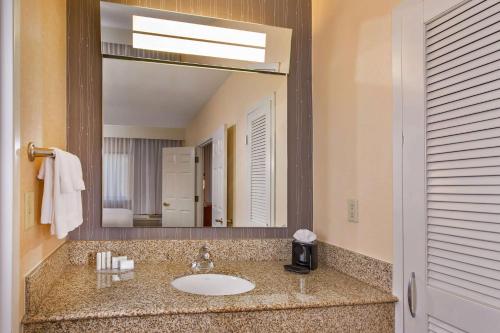 a bathroom with a sink and a large mirror at Sonesta Select Charlotte University Research Park in Charlotte