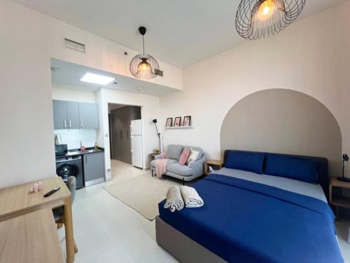 a bedroom with a blue bed and a living room at Warm and Elegant Studio in Dubai in Dubai