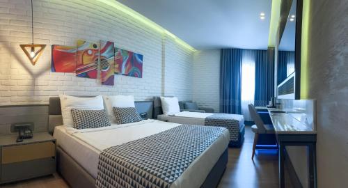 アンタルヤにあるLaren Family Hotel & Spa - Boutique Classのベッドとソファ付きのホテルルーム
