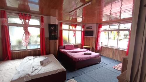 um quarto com 2 camas e 2 janelas em Taiga Homestay, Lepchajagat, Darjeeling em Darjeeling
