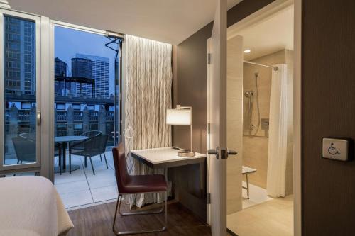 a hotel room with a bed and a desk and a bathroom at Embassy Suites By Hilton New York Manhattan Times Square in New York