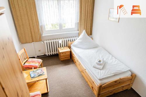 a small room with a bed and a window at Pension zum Hexenstieg in Schierke