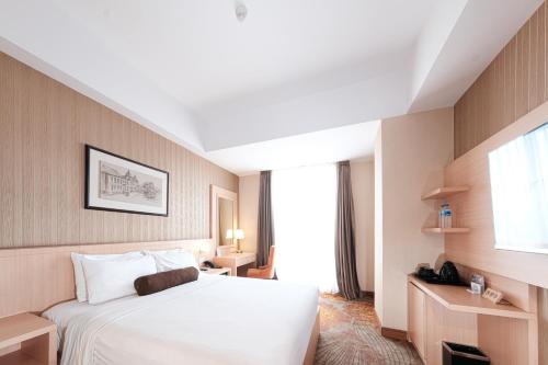 a hotel room with a bed and a window at Hotel Chanti Managed by TENTREM Hotel Management Indonesia in Semarang