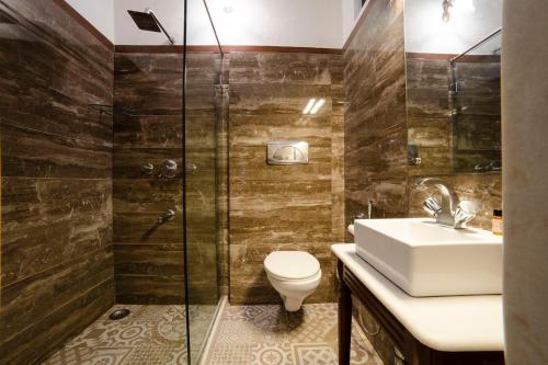 a bathroom with a shower and a toilet and a sink at Hotel Pearl Palace Jaipur in Jaipur