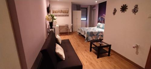 a living room with a couch and a bed at Hostal Happystay in Valencia