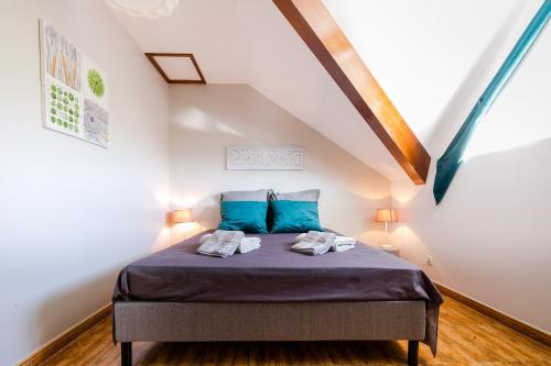 una camera da letto con letto e cuscini blu di Kaz Combava a Étang-Salé