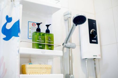 a bathroom with two green bottles on a shelf at เพชรมณีกาญจน์ บีช รีสอร์ท in Ban Plai Huai Kaeng Riang